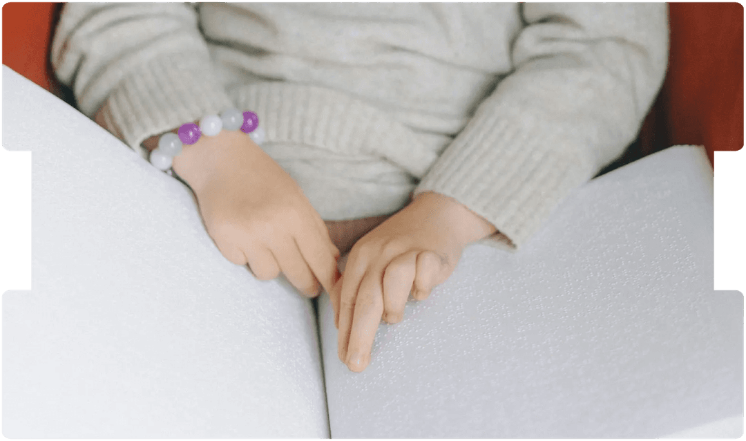 Child reading a braille book, symbolising the impact of cerebral visual impairment and its medico-legal considerations in paediatric care.