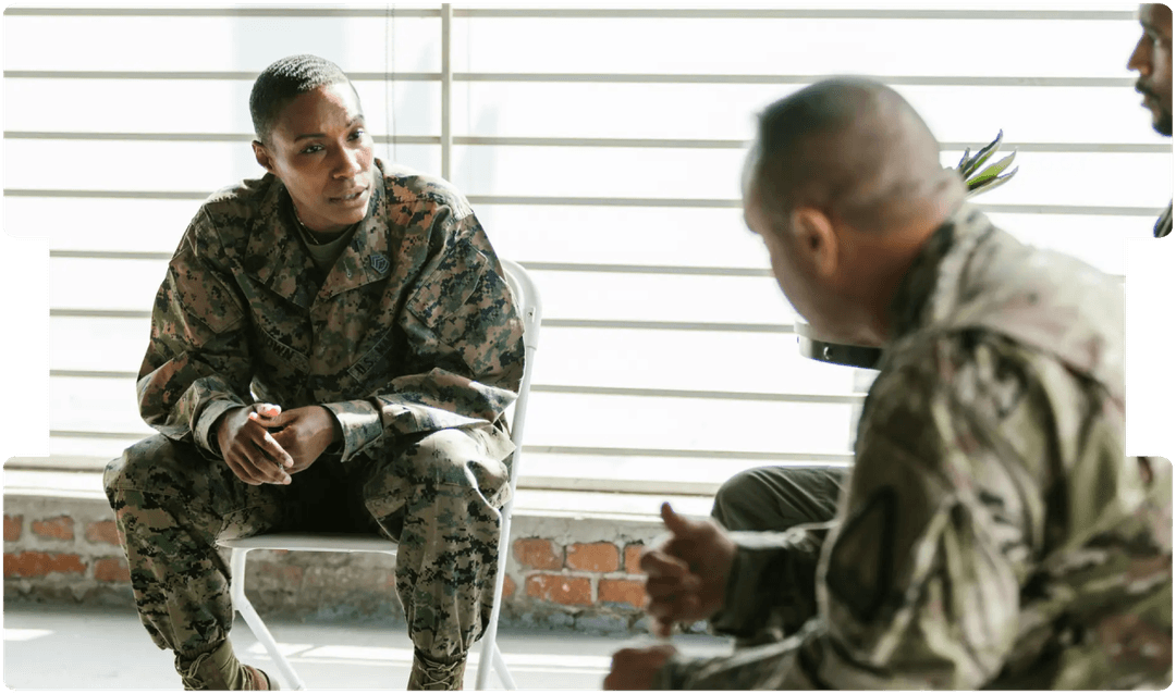 Military personnel in discussion, representing the psychological impact of service and the need to understand trauma beyond physical injury.