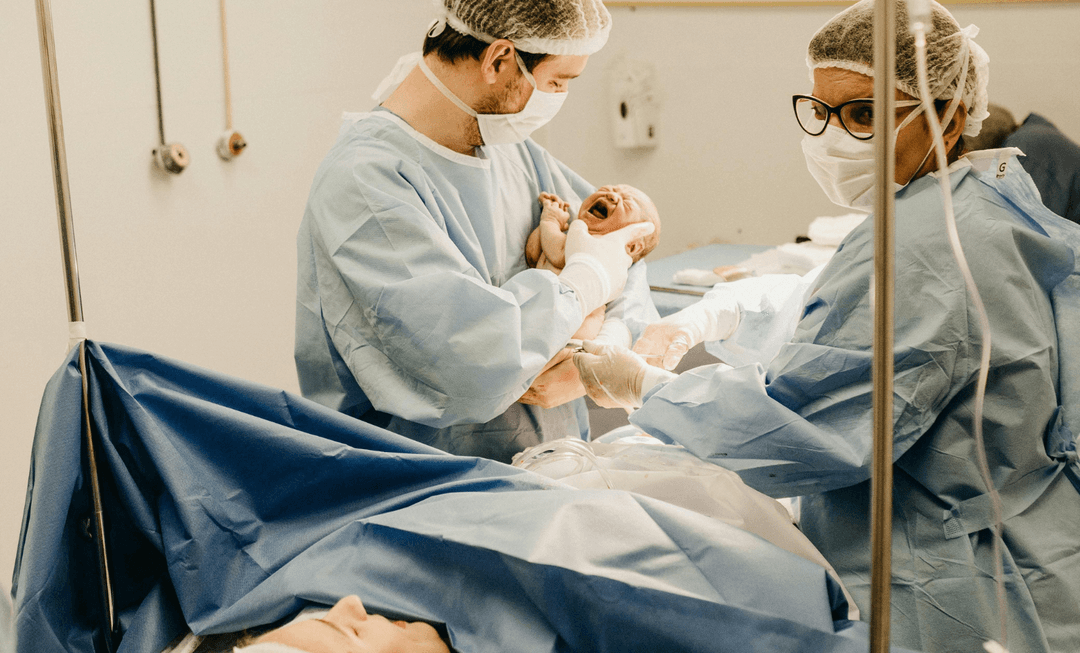 Medical team delivering a newborn in a hospital, highlighting adherence to clinical guidelines and their role in birth injury claims.