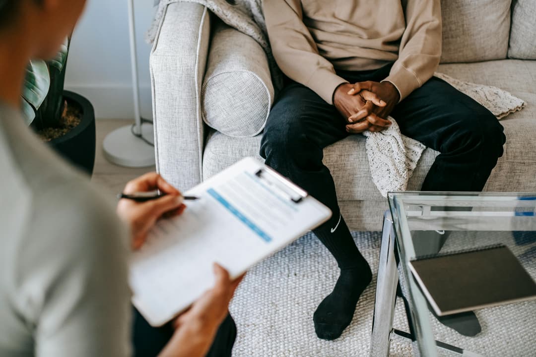 Psychologist taking notes during a therapy session, highlighting the role of mental health assessment in personal injury cases involving depression.