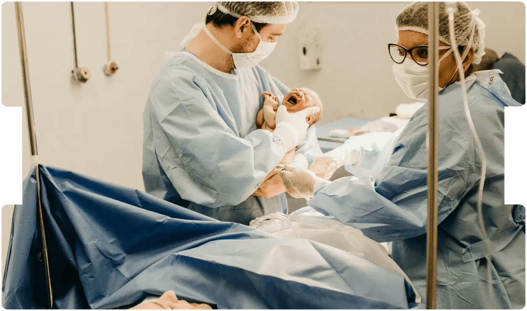 Medical team delivering a newborn in a hospital, highlighting adherence to clinical guidelines and their role in birth injury claims.