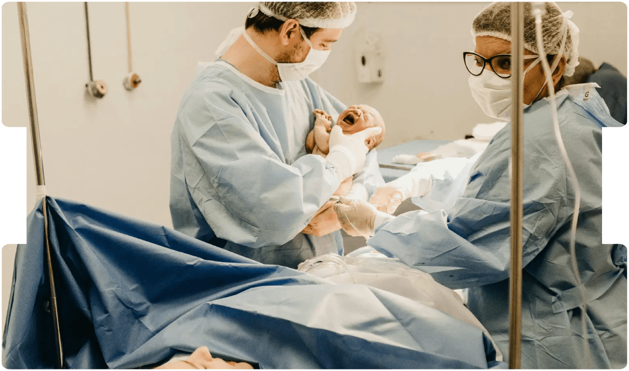 Medical team delivering a newborn in a hospital, highlighting adherence to clinical guidelines and their role in birth injury claims.