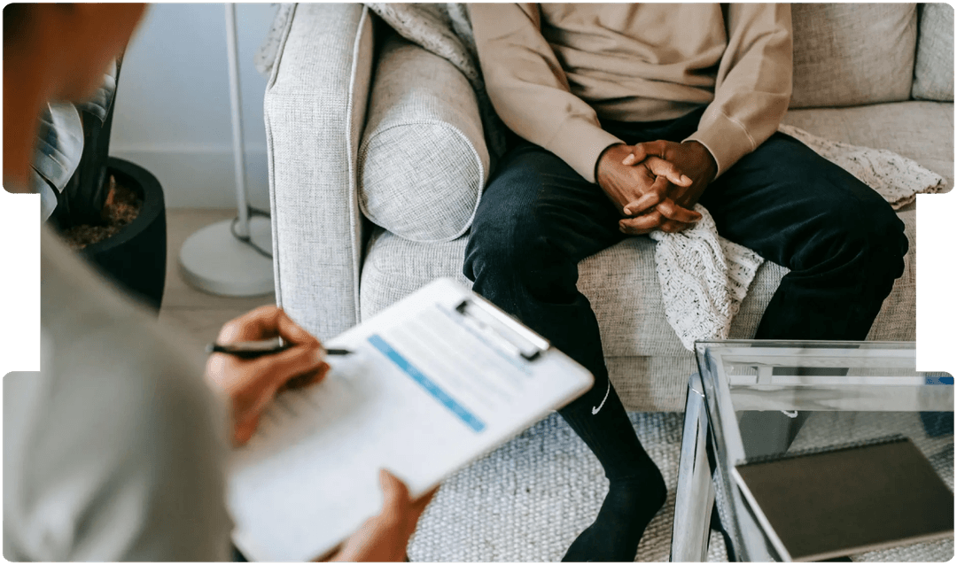 Psychologist taking notes during a therapy session, highlighting the role of mental health assessment in personal injury cases involving depression.