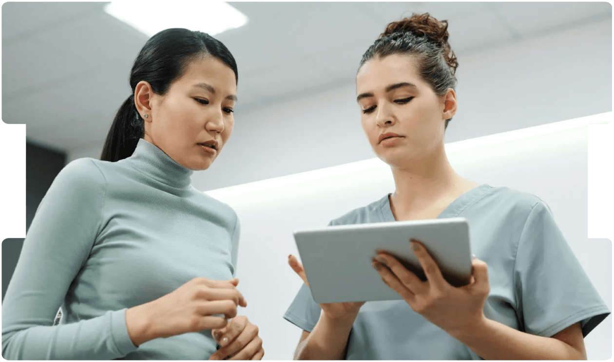 Healthcare professionals reviewing patient data on a tablet, reflecting the need for detailed, multidisciplinary assessment in endometriosis care.