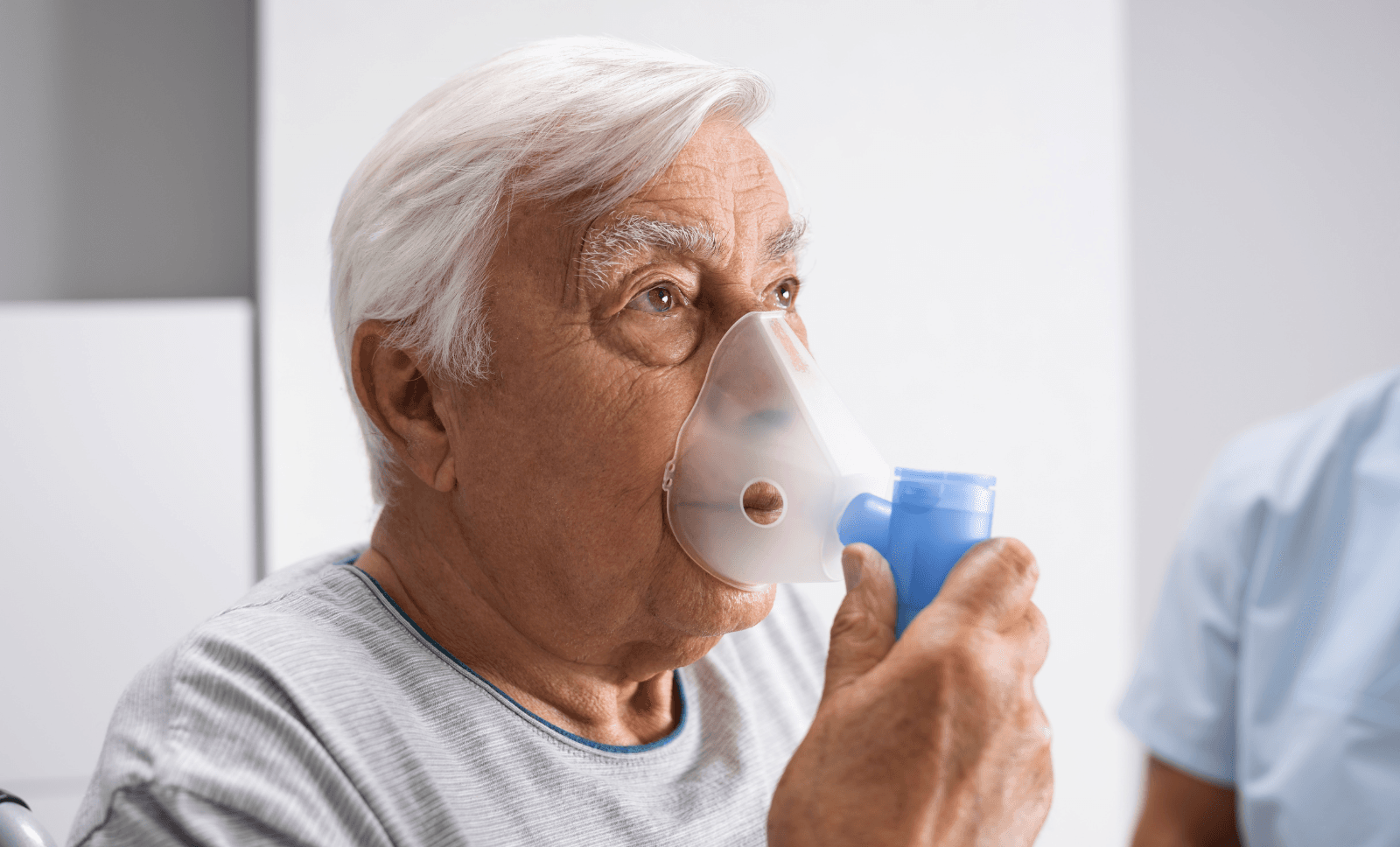 Elderly man using a nebulizer for COPD treatment, managing chronic lung disease with respiratory therapy support.