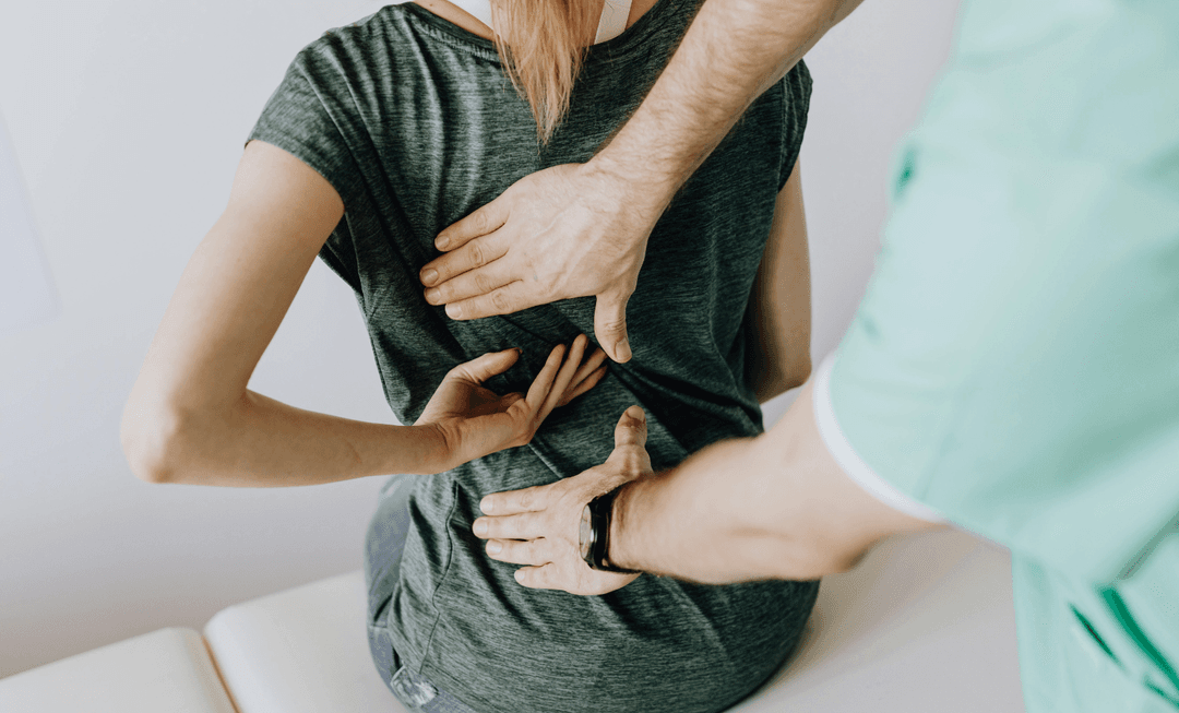 Doctor examining a patient’s back, symbolising precision, care, and awareness of surgical complications in paediatric medical practice.