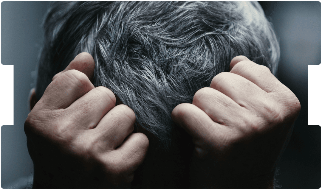 Person holding their head in distress, representing symptoms of schizophrenia or severe mental illness.