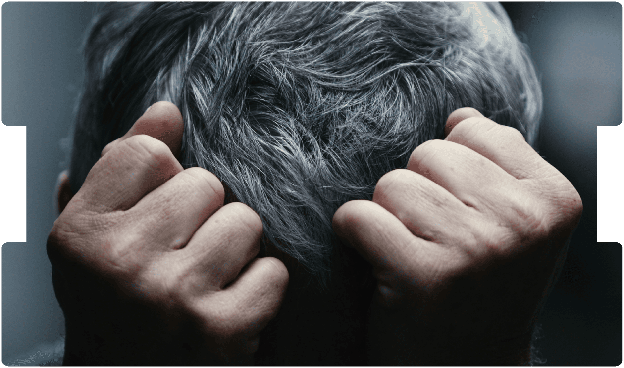 Person holding their head in distress, representing symptoms of schizophrenia or severe mental illness.