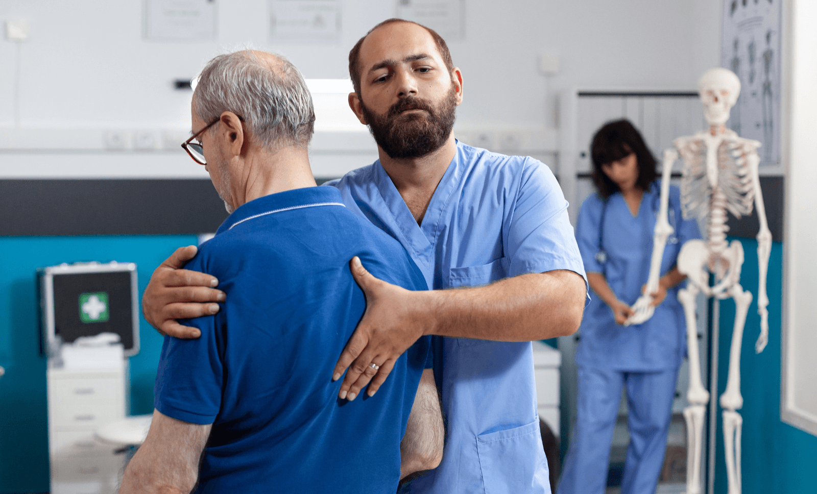 Physiotherapist guiding elderly man through shoulder mobility exercise in clinic, supporting posture and rehabilitation therapy.
