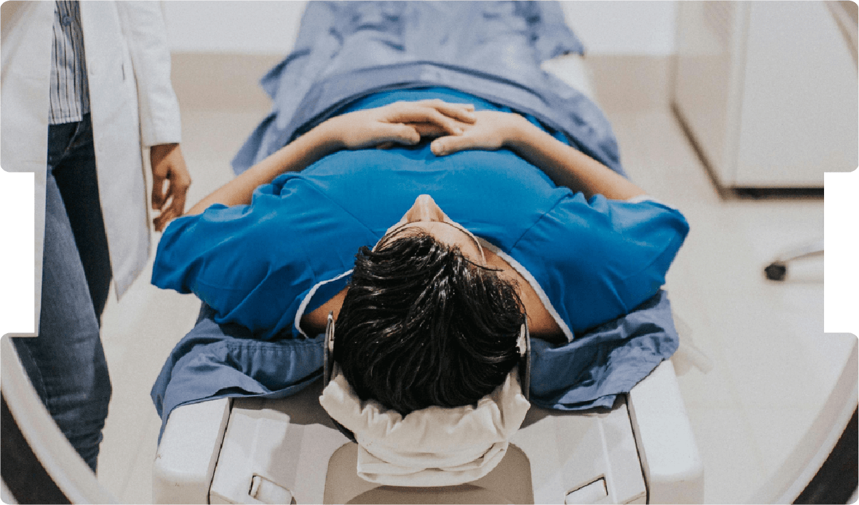 Patient lying in MRI scanner with clinician nearby, highlighting diagnostic imaging, medical assessment, and expert witness work.