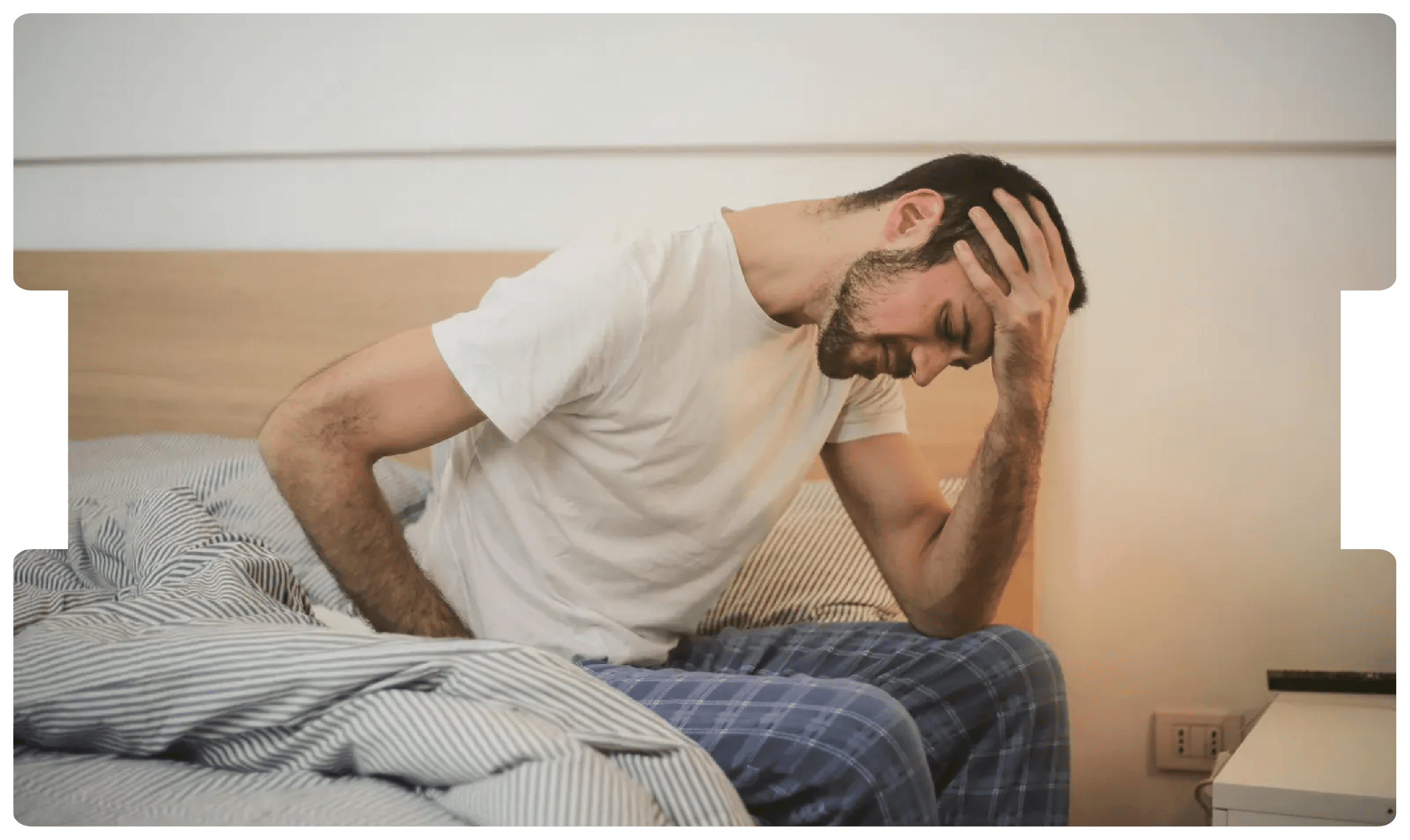 Man sitting on bed in visible pain, representing the urgent symptoms and medico-legal implications of delayed testicular torsion diagnosis.