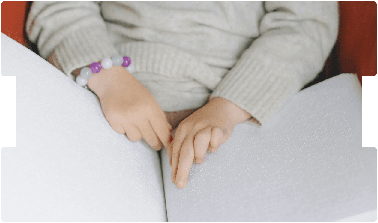 Child reading a braille book, symbolising the impact of cerebral visual impairment and its medico-legal considerations in paediatric care.