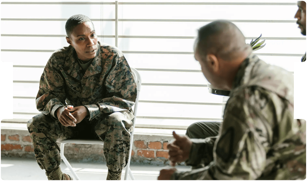 Military personnel in discussion, representing the psychological impact of service and the need to understand trauma beyond physical injury.