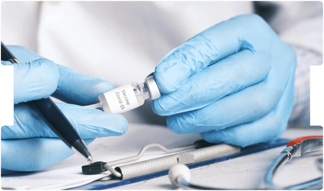 Doctor holding a COVID-19 vaccine vial while making notes, representing key medico-legal considerations surrounding vaccination and consent.