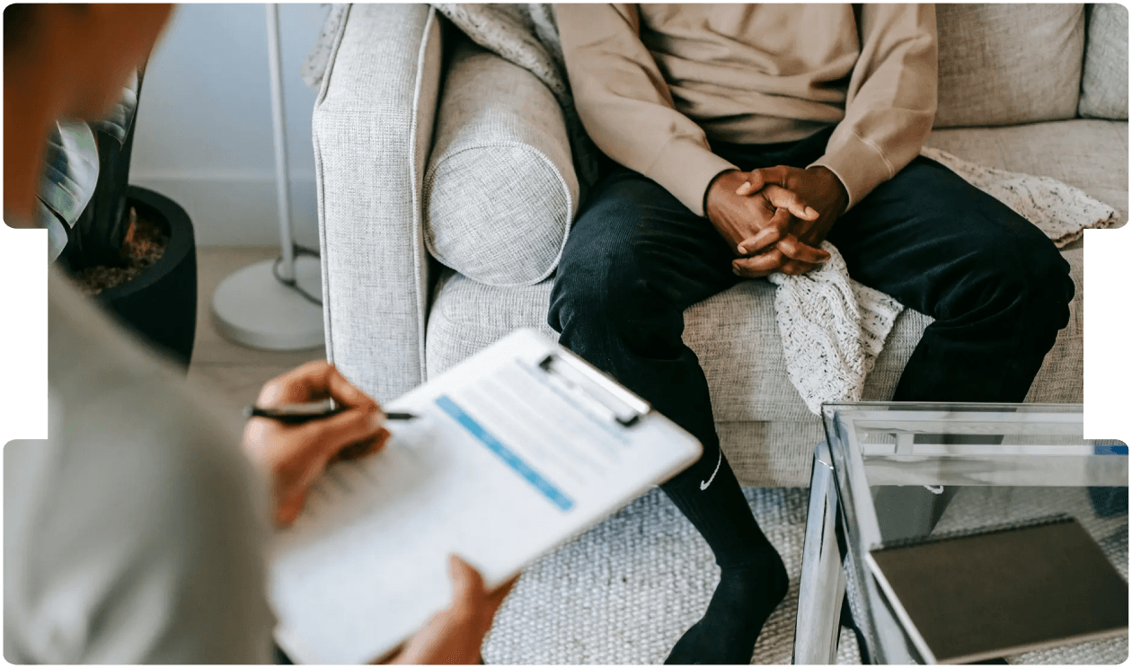 Psychologist taking notes during a therapy session, highlighting the role of mental health assessment in personal injury cases involving depression.