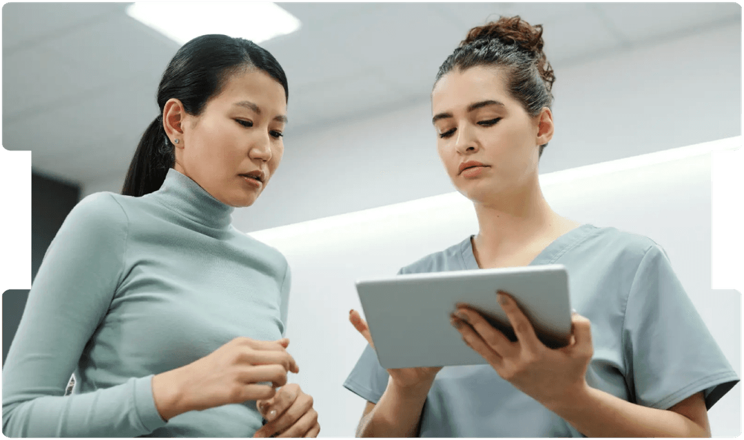 Healthcare professionals reviewing patient data on a tablet, reflecting the need for detailed, multidisciplinary assessment in endometriosis care.