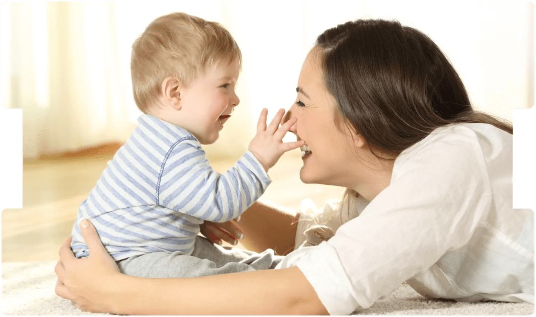 Smiling mother playing with her baby, symbolising trust and communication central to informed consent in obstetric emergencies.