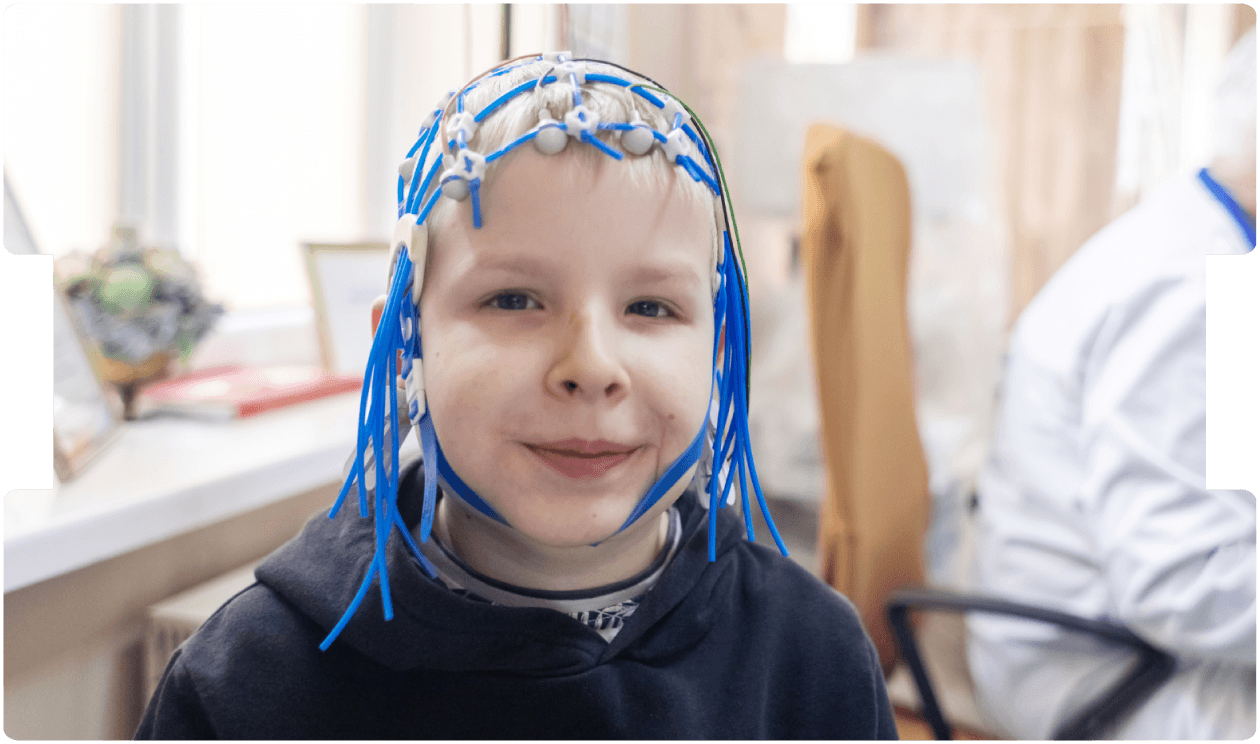 Child sits calmly during a paediatric EEG exam, supporting gentle neurological assessment with specialist brain-activity monitoring.
