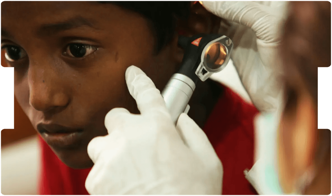Doctor examining a child’s ear with an otoscope, illustrating the risks and medical implications associated with chronic ear infections.
