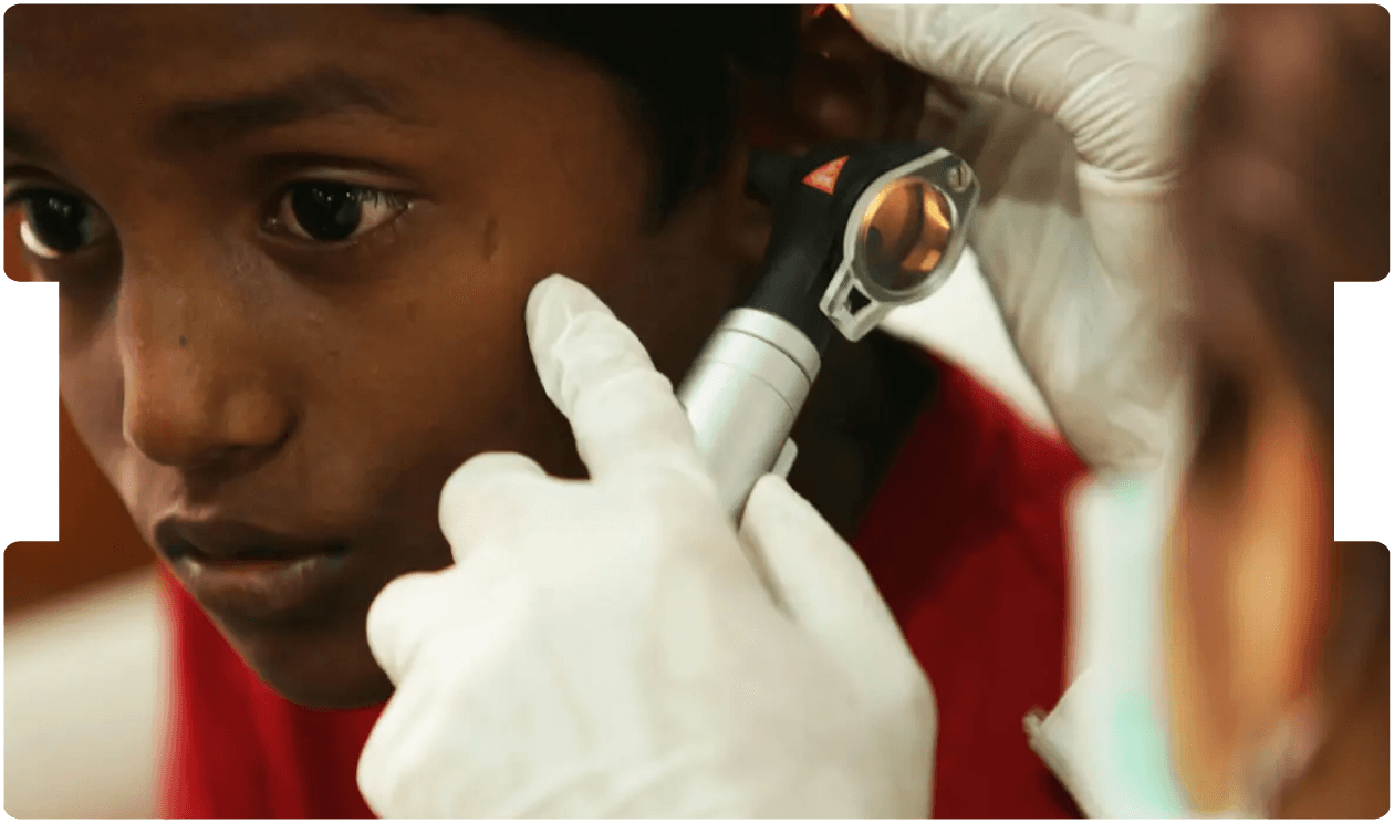 Doctor examining a child’s ear with an otoscope, illustrating the risks and medical implications associated with chronic ear infections.