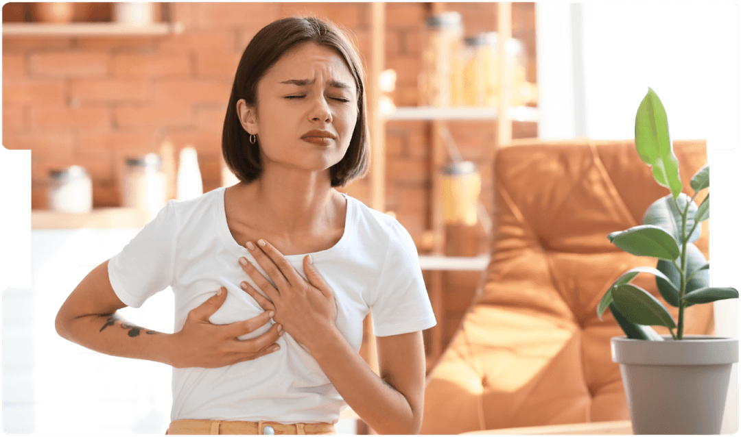 Woman clutching her chest in discomfort, showing possible symptoms of breast pain or breast cancer.
