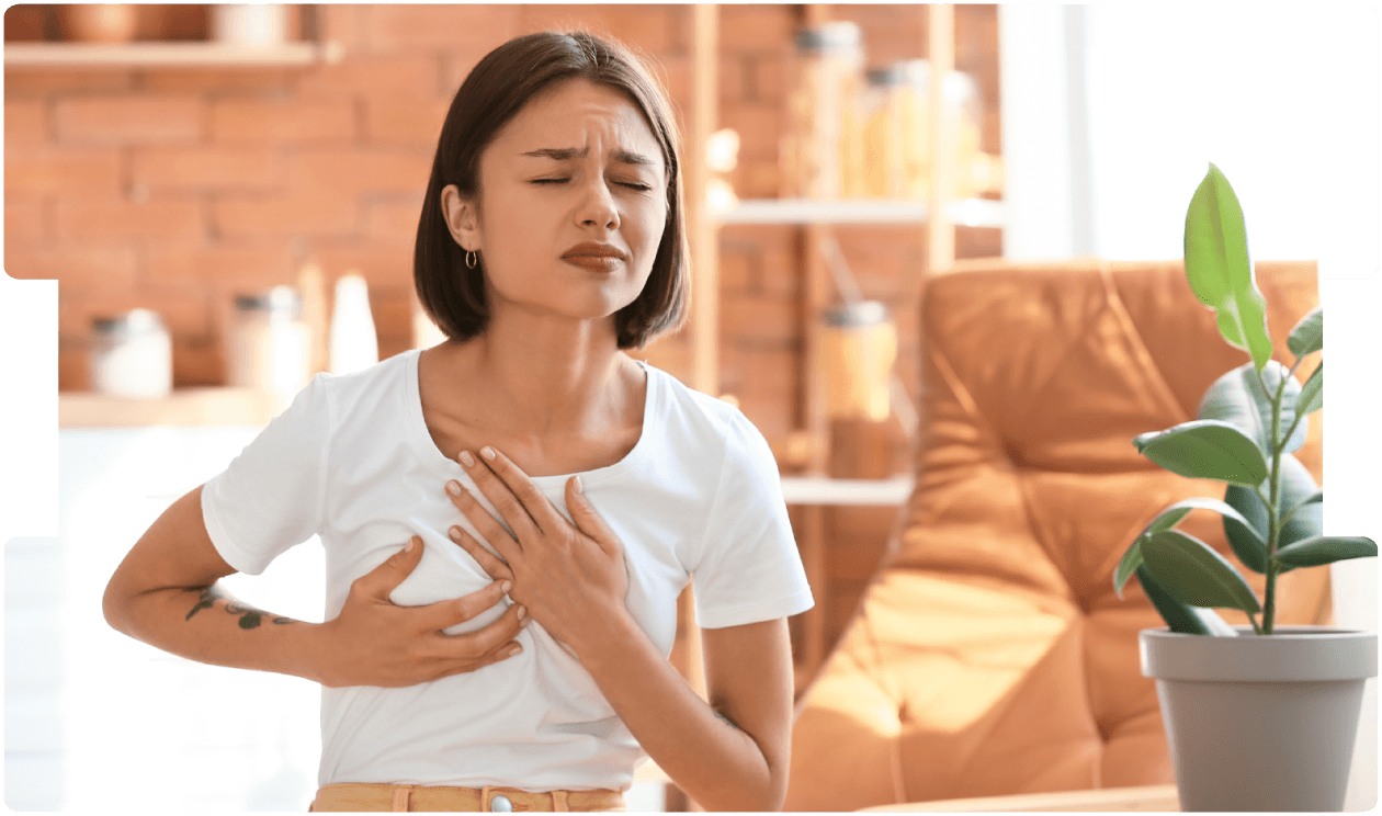 Woman clutching her chest in discomfort, showing possible symptoms of breast pain or breast cancer.
