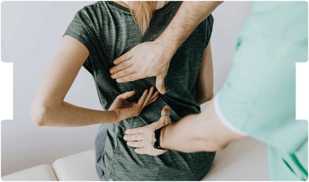 Doctor examining a patient’s back, symbolising precision, care, and awareness of surgical complications in paediatric medical practice.