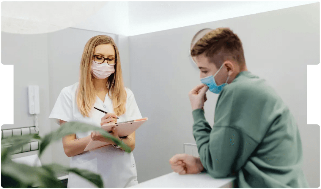 Healthcare professional consulting a patient while wearing masks, reflecting adaptations in medico-legal reporting during the COVID-19 pandemic.